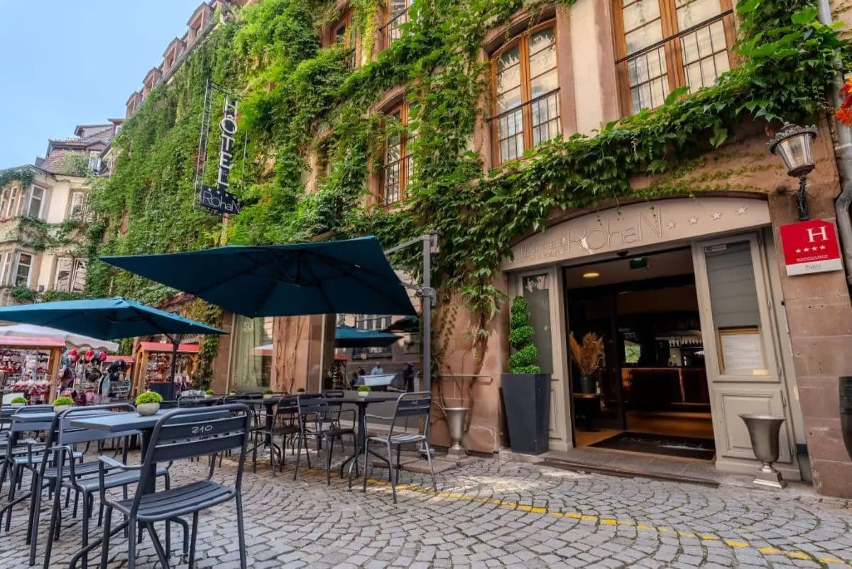 Entrée de l’Hôtel Rohan Strasbourg avec terrasse extérieure et façade recouverte de végétation