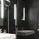 Elegantes Badezimmer mit schwarzer Mosaikfliese und beleuchtetem Spiegel im Deluxe Zimmer im Hotel Rohan Straßburg