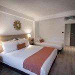 Overall view of a triple room at Hotel Rohan Strasbourg with double bed and wall decoration