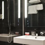 Modernes Badezimmer im Deluxe Zimmer im Hotel Rohan in Straßburg mit Dusche und modernem Waschbecken